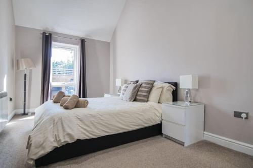 Un dormitorio blanco con una cama grande y una ventana en Hoxne Cottages - Sunflower Cottage with private hot tub en York