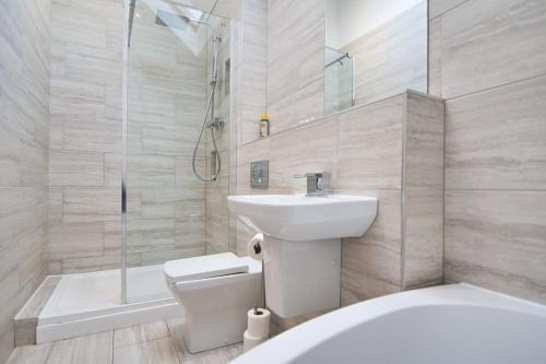 Hoxne Cottages - Sunflower Cottage with private hot tub في يورك: حمام مع حوض ومرحاض ودش