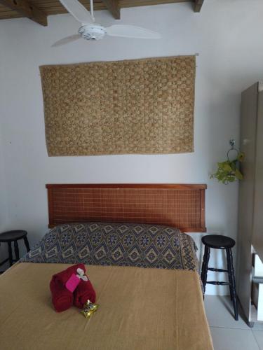 a stuffed animal sitting on a bed in a bedroom at Apartamento - Praia da Ferrugem com Espaço Gourmet in Palhocinha