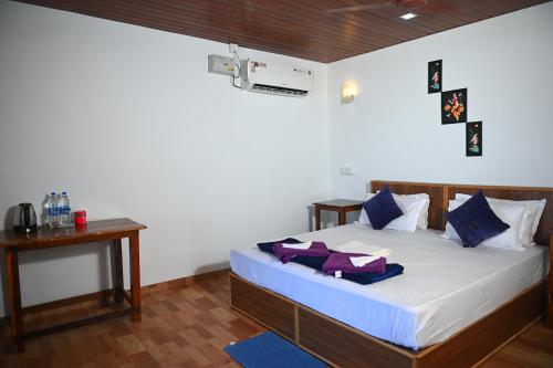 1 dormitorio con 1 cama con almohadas azules y moradas en Madhu Huts Agonda, en Agonda