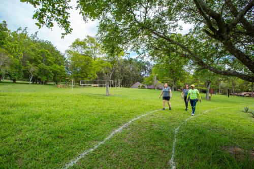 three people walking down a path in a field at Itu Garden - SPA e Resort Saudavel in Itu