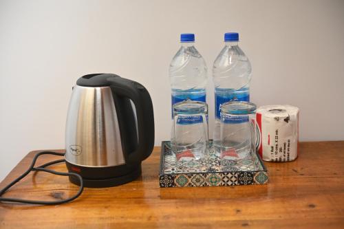 a coffee maker and two bottles of water on a table at Madhu Huts Agonda in Agonda