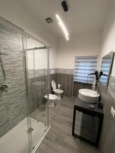 a bathroom with two toilets and a glass shower at Foresteria Opera B&b in Rovato