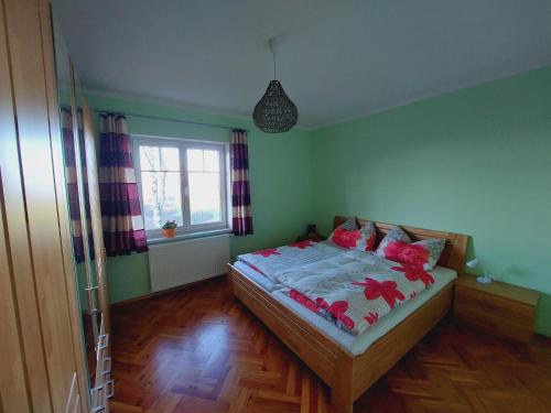Un dormitorio con una cama con flores rojas. en Ferienwohnung Lucy am Lonitzberg, en Steinakirchen am Forst