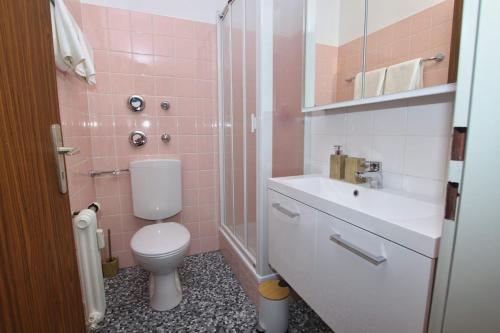 een roze badkamer met een toilet en een wastafel bij Ferienwohnung in Freilassing
