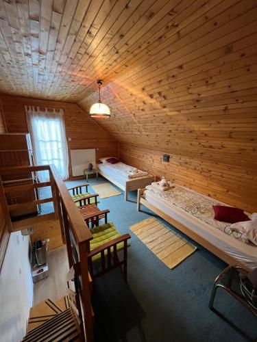 a room with three beds in a wooden cabin at Apartments Jelka in Kranjska Gora