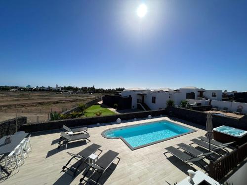 a swimming pool with chaise lounge chairs and a swimming pool at Villa Little Star in Playa Blanca