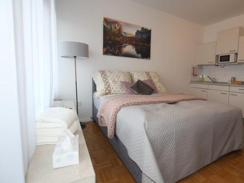 een kleine slaapkamer met een bed en een keuken bij Ferienwohnung in Freilassing