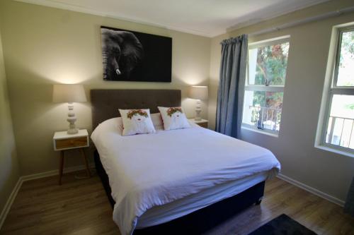 a bedroom with a bed with white sheets and pillows at Tamboerskloof 2 bed apartment in Cape Town