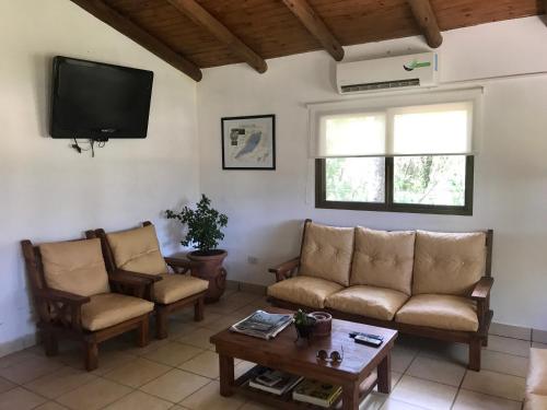 sala de estar con 2 sofás y TV en Posada Che Teindy en Colonia Carlos Pellegrini