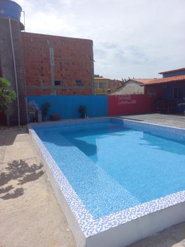 a large swimming pool with blue water in front of a building at Pousada Lençóis do Delta in Tutóia