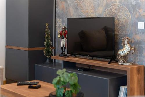 sala de estar con mesa y TV en Kalman Royal Inn, en Zlatibor
