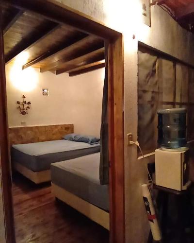 a room with two beds and a door with a window at Hotel Colibrí Petén in Santa Elena