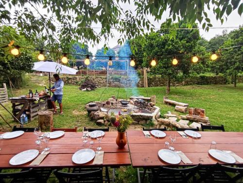 a wooden table with plates and wine glasses on it at Verde Água Agroturismo e Agricultura Biológica in Couto