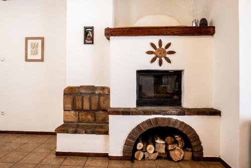 a living room with a fireplace with logs in it at Pension Styl in Bedřichov