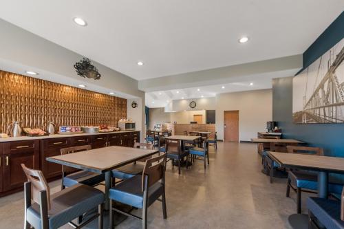 a restaurant with tables and chairs and a counter at SureStay Plus Hotel by Best Western Highland Poughkeepsie in Highland
