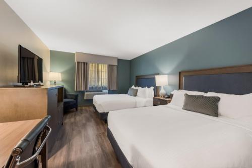 a hotel room with two beds and a flat screen tv at SureStay Plus Hotel by Best Western Highland Poughkeepsie in Highland