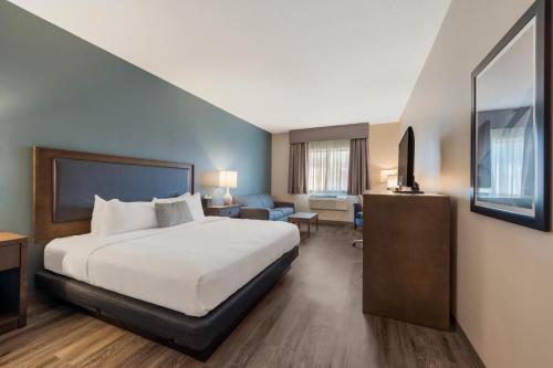 a hotel room with a bed and a tv at SureStay Plus Hotel by Best Western Highland Poughkeepsie in Highland