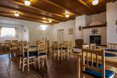a restaurant with wooden tables and chairs and a fireplace at Pension Styl in Bedřichov