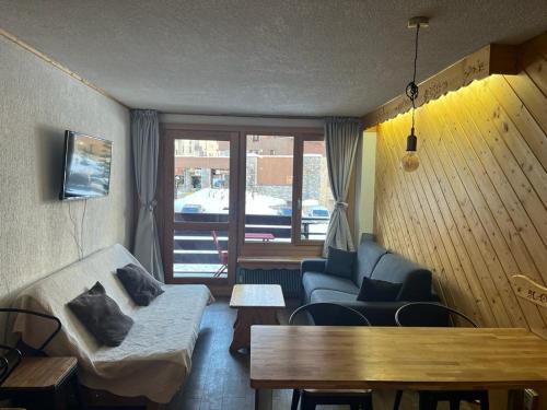 ein Wohnzimmer mit einem Sofa und einem Tisch in der Unterkunft Grand 2 pièces traversant au Val Claret, 4 à 6 pers in Tignes