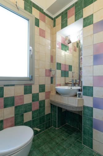 a bathroom with a sink and a toilet and a mirror at Oniro Luxury Villas in Toroni