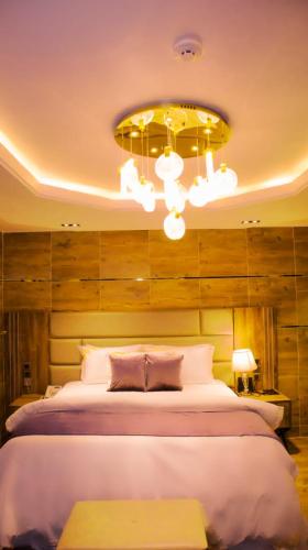 a bedroom with a large bed and a chandelier at TN MAX LUXURY HOME in Enugu