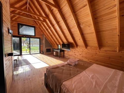 una camera con un letto in una stanza con pareti in legno di Pinhan Otel Kazdağıları a Ayvacık