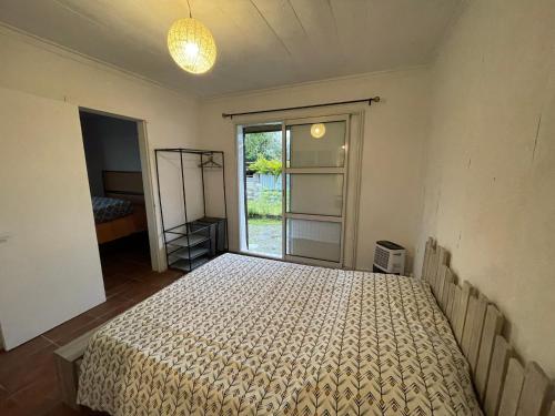 ein Schlafzimmer mit einem Bett in einem Zimmer mit einem Fenster in der Unterkunft Chez KAKINE in La Plaine des Palmistes