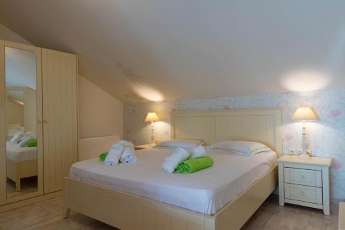 a bedroom with a large white bed with two lamps at Oniro Luxury Villas in Toroni