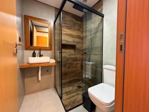 a bathroom with a shower and a toilet and a sink at Casa Oceano Praia do Rosa, apartamentos pé na areia, Praia do Rosa in Praia do Rosa