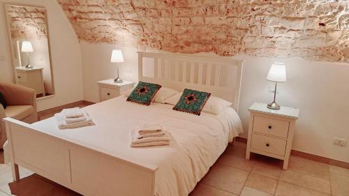 een slaapkamer met een groot wit bed en 2 nachtkastjes bij Dimora Imma in Conversano