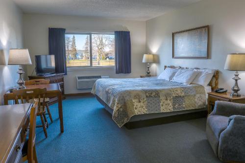 a hotel room with a bed and a television at Lighthouse Inn - Two Rivers in Two Rivers