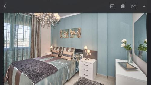 una camera da letto con pareti blu e un letto con comodino di Chalet de lujo a Pulpí