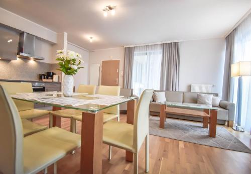 a dining room and living room with a table and chairs at Apartamenty Na Wyspie - Casa Marina - Parking in Świnoujście