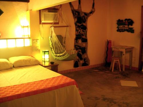 a bedroom with a bed and a hammock hanging from the wall at Art Hotel Aos Sinos Dos Anjos in Arraial d'Ajuda