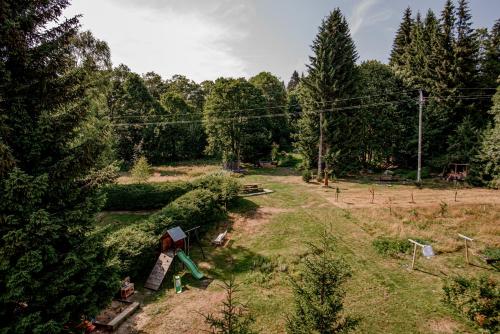 a backyard with a playground with an umbrella and trees at Pension Styl in Bedřichov