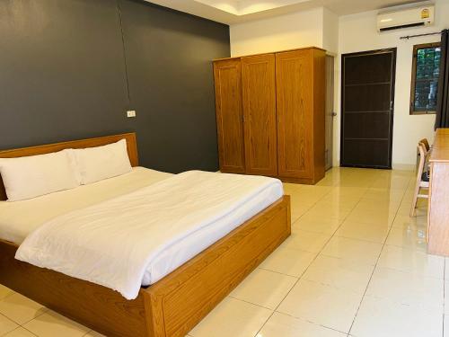 a bedroom with a large bed with white sheets at JJ Palace เจเจ พาเลซ in Ban Si Than