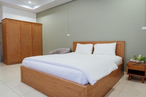 a bedroom with a large bed with white sheets at JJ Palace เจเจ พาเลซ in Ban Si Than