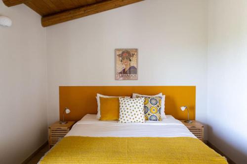 une chambre avec un lit avec des draps et des oreillers jaunes dans l'établissement Casa Monteverdi, à Vinchio