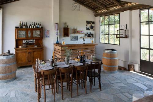 une salle à manger avec une table et quelques tonneaux de vin dans l'établissement Casa Monteverdi, à Vinchio