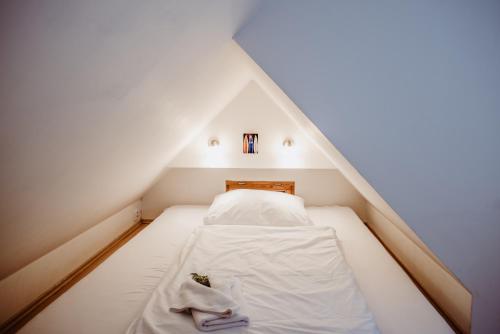 a small room with a bed in a attic at Pension Styl in Bedřichov