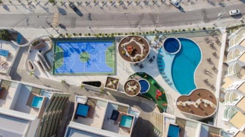 an overhead view of a resort with a swimming pool at 2 QUARTOS a 50m PRAIA dos Anjos em Condomínio Club com PISCINA, estacionamento e portaria 24h - Área de lazer 3000m, wi-fi 450MB, churrasqueira e cozinha completa in Arraial do Cabo