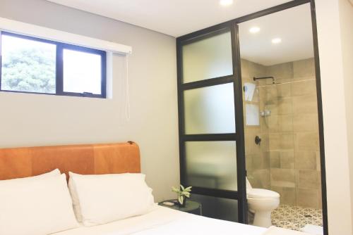 a bedroom with a shower and a bed and a toilet at 574 Hotel in Medellín