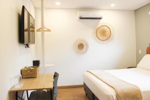 a bedroom with a bed and a desk and a tv at 574 Hotel in Medellín