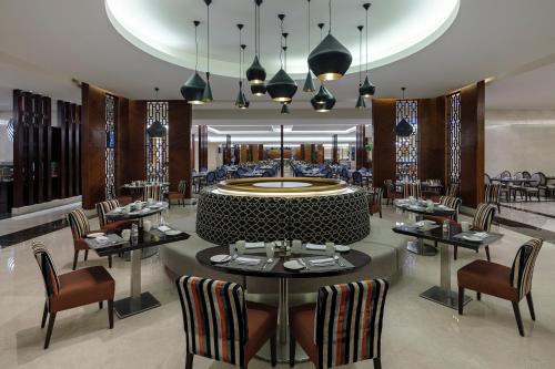 a dining room with tables and chairs in a restaurant at Swissotel Makkah in Makkah