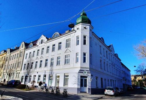 a large white building with a clock tower on a street at Mezzanine de Grinzing in Vienna