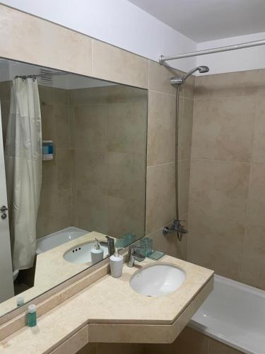 Metropolitan Highline Apartments في بوينس آيرس: حمام مع حوض وحوض استحمام مع مرآة