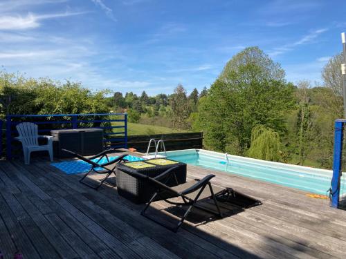 une terrasse avec une piscine, 2 chaises et une télévision dans l'établissement La maison charmante d'Elisabeth, à Saint-Ybard