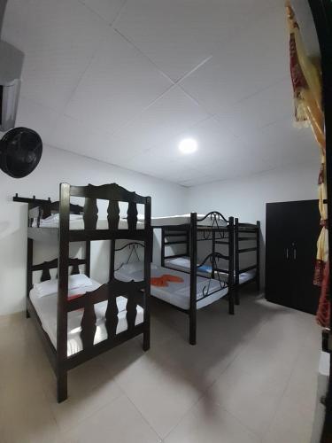 a room with three bunk beds in it at Hostal Villa del Río Las Brisas in Villavieja