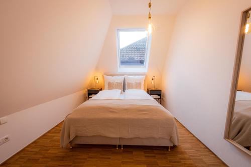 ein kleines Schlafzimmer im Dachgeschoss mit einem Bett und einem Fenster in der Unterkunft BONNYSTAY Passau Downtown - mitten in der Altstadt Passau`s in Passau